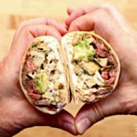Hands making a heat shape with the California Burrito inside the heart.