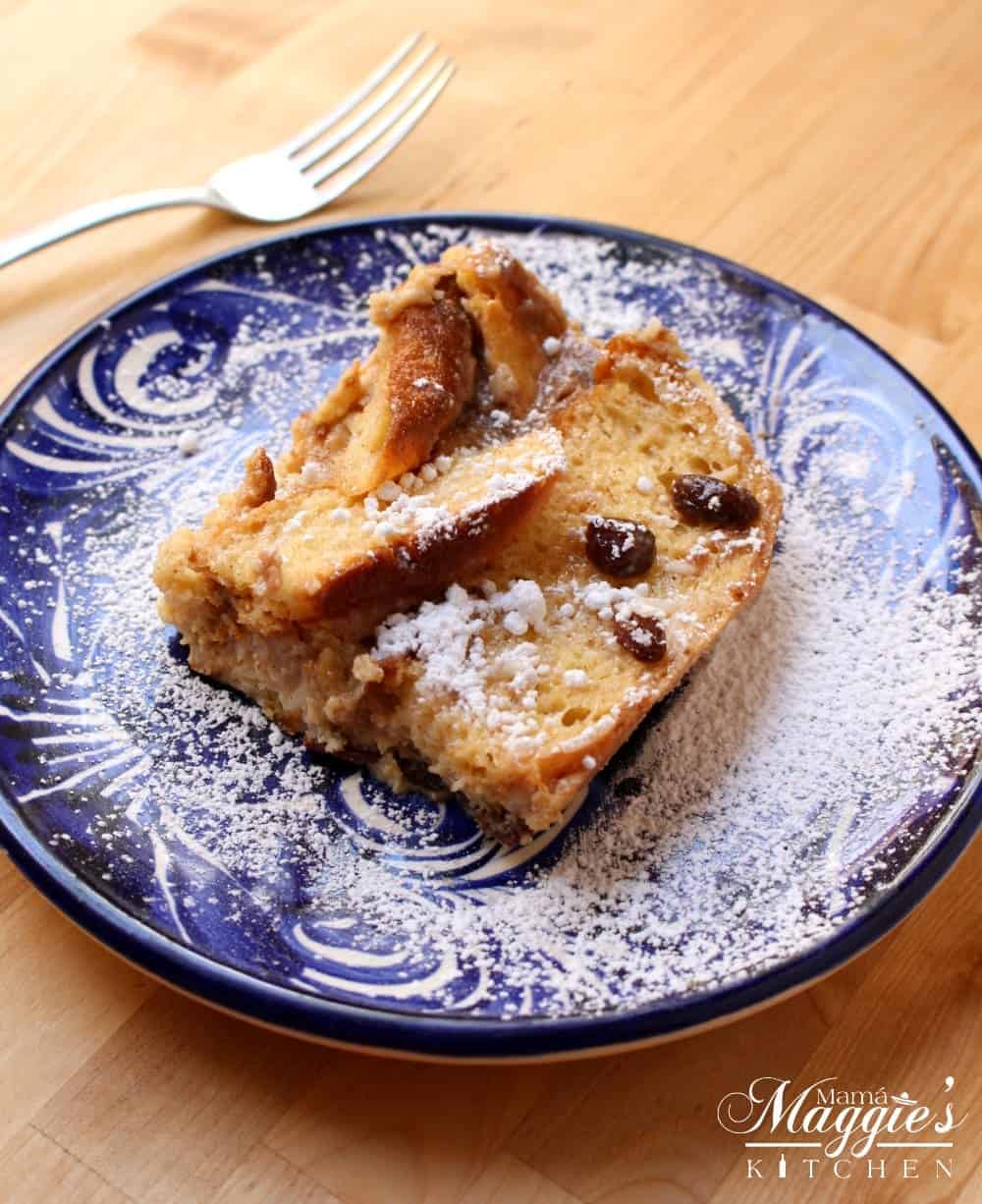 Conchas Bread Pudding on a blue plate with a fork on the side.