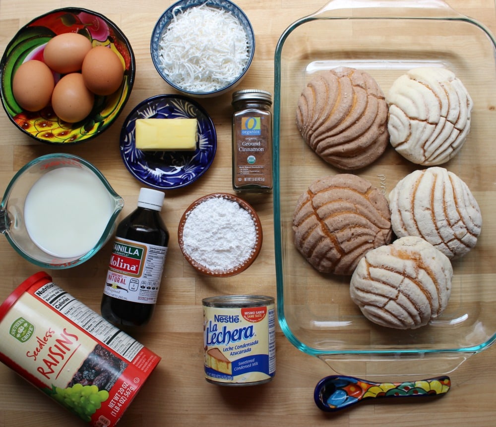 The ingredients for Conchas Bread Pudding (Capirotada de Conchas) on a wooden surface.