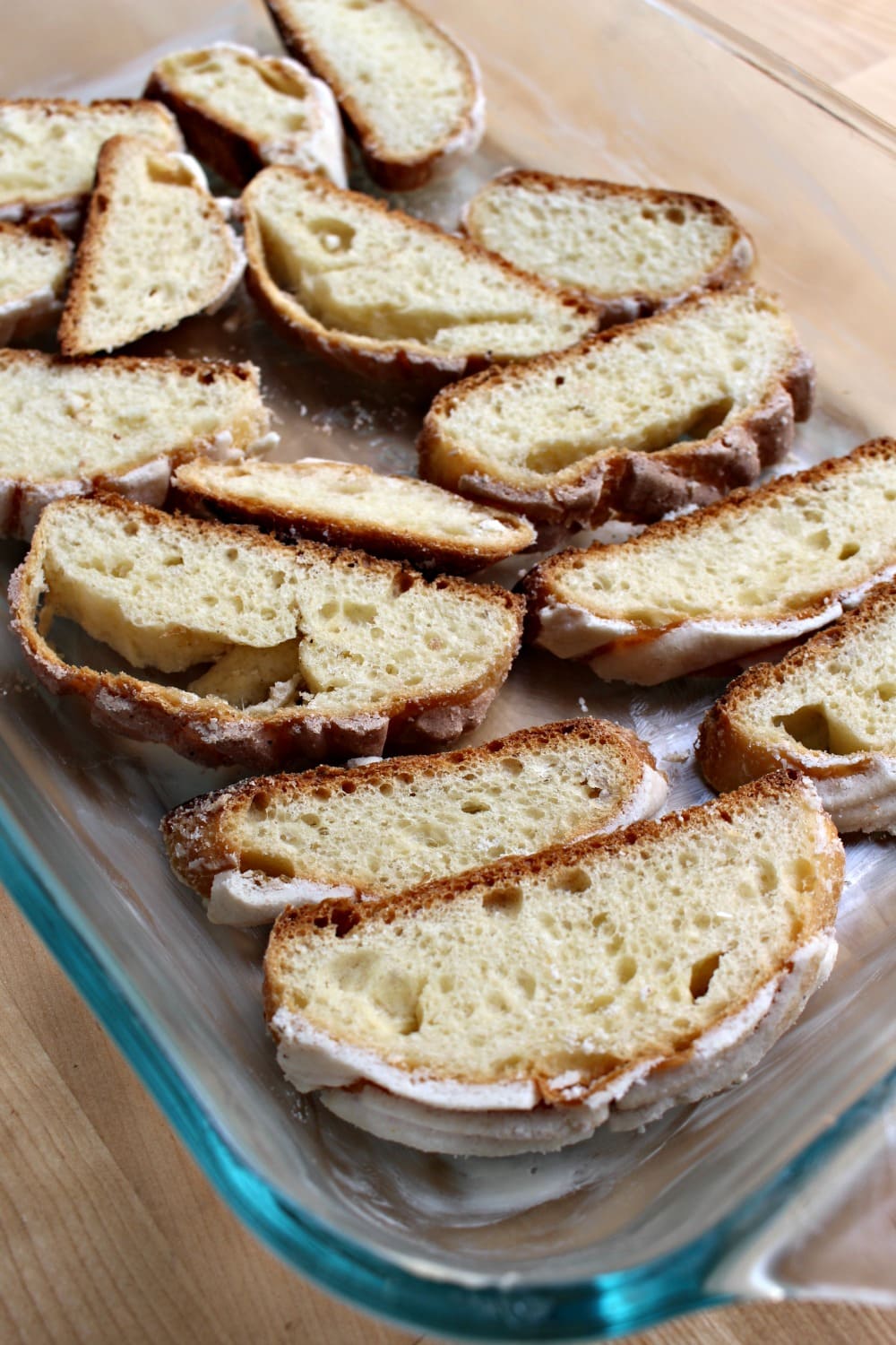 Sliced conchas in a single layer on a glass container.