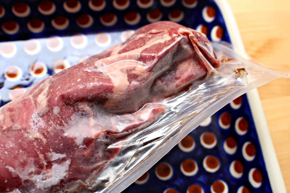  Vacuum sealed beef package on a blue plate.