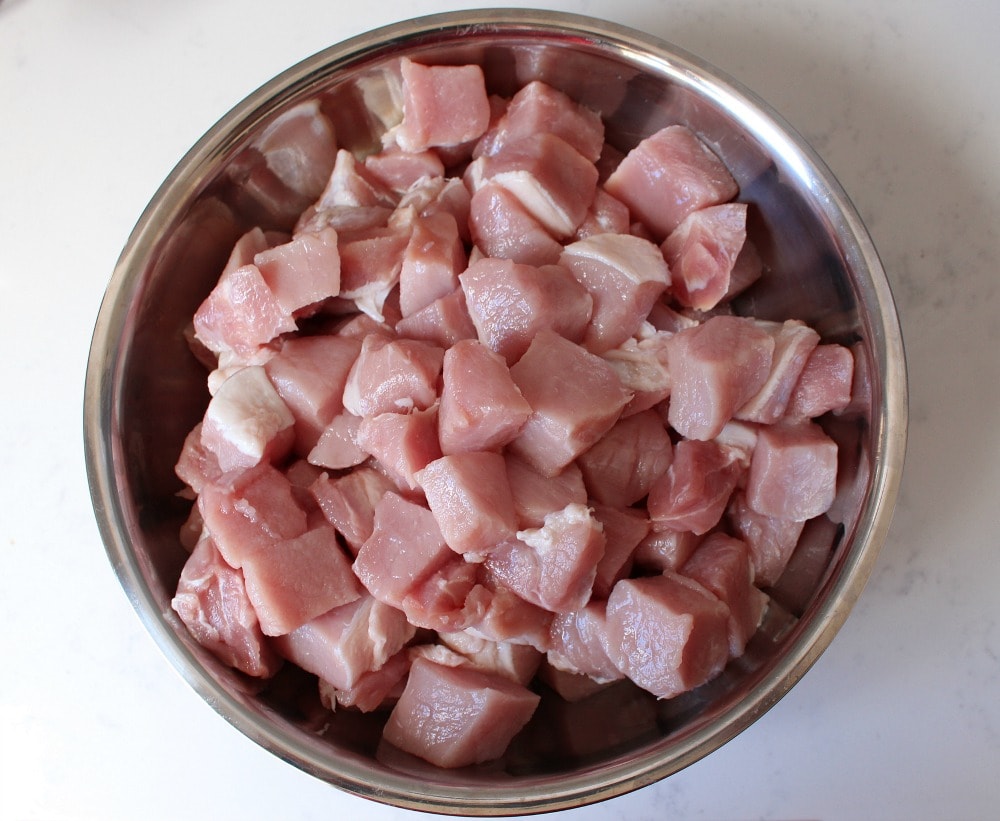 Chopped raw pork loin pieces in a bowl.