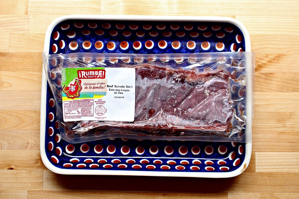 Outside Skirt Steak on a blue plate and still in the package.