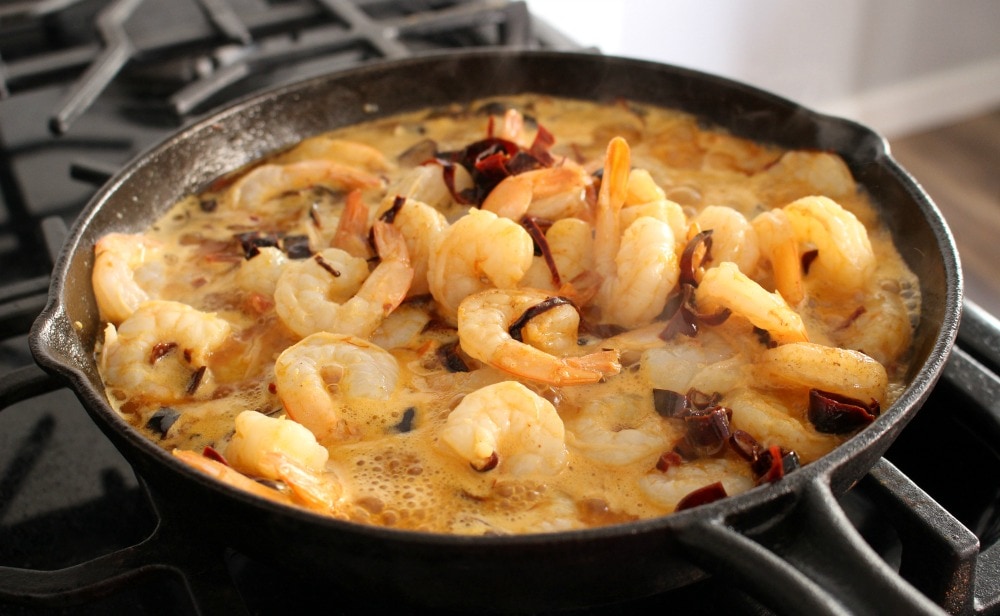 Shrimp cooking in a cast iron skillet along with the dried chiles.