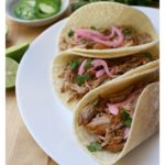 Cochinita Pibil tacos are to die for. Incredibly tender meat topped with chopped cilantro and cebolla en escabeche (pickled red onions). Each bite is heavenly. Recipe with Video and step-by-step pictures. By Mama Maggie’s Kitchen