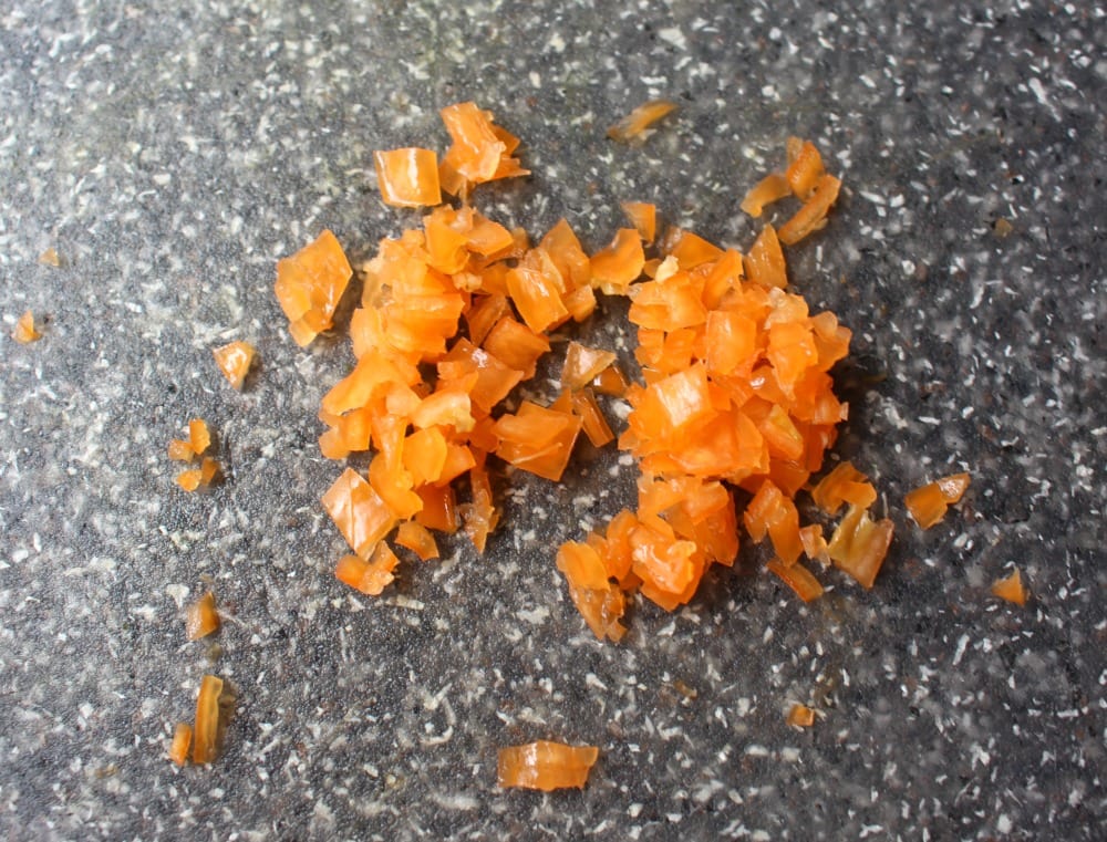 Diced habanero pepper on a black granite surface.