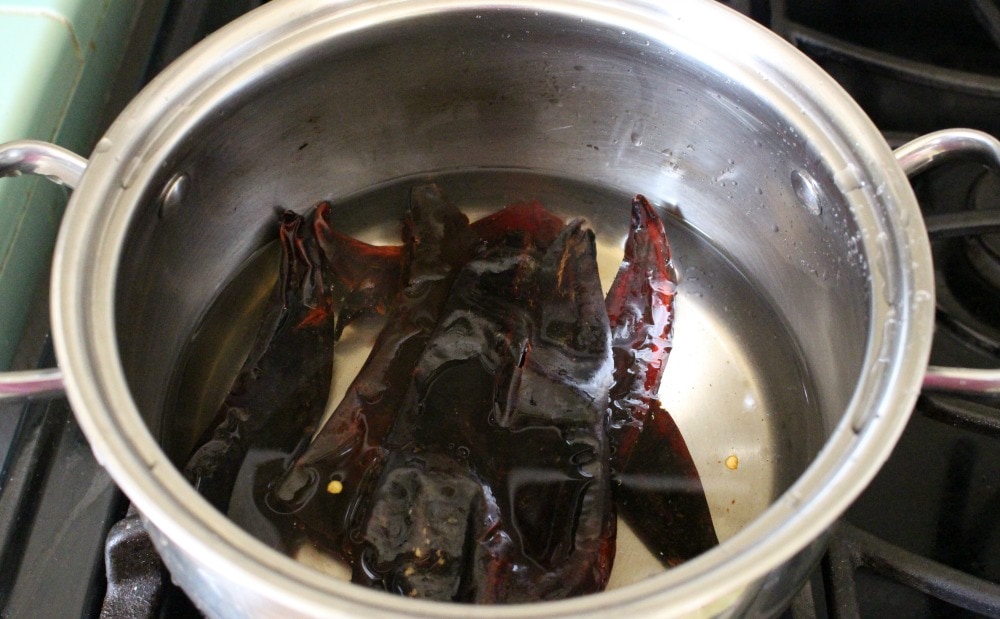 Chile Guajillo inside a stock pot with water.