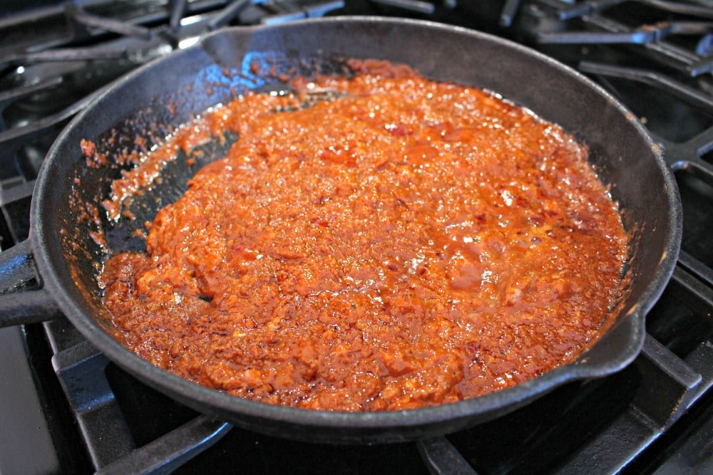 Chorizo cooking in a black iron skillet.