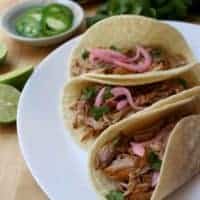 Cochinita Pibil tacos are to die for. Incredibly tender meat topped with chopped cilantro and cebolla en escabeche (pickled red onions). Each bite is heavenly. Recipe with Video and step-by-step pictures. By Mama Maggie's Kitchen