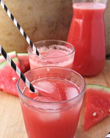 Two glasses of Watermelon Agua Fresca with black and white straws.