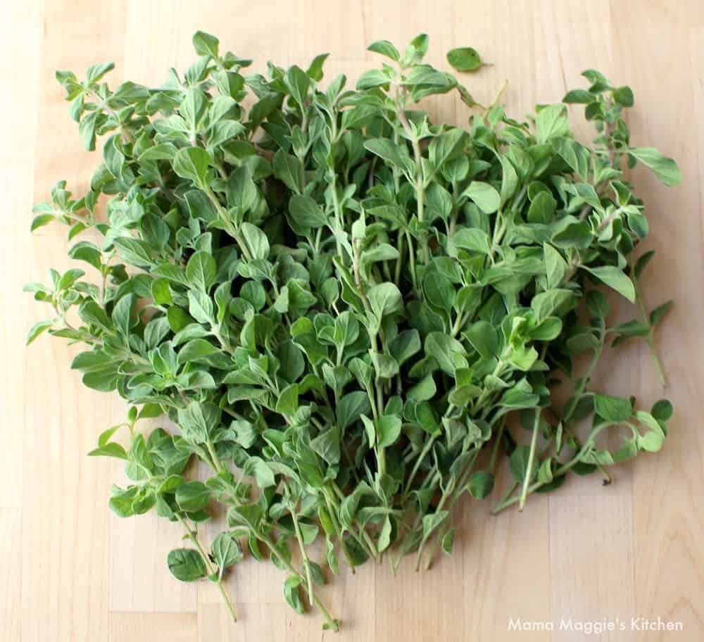 Fresh oregano laid out on a wooden surface. 