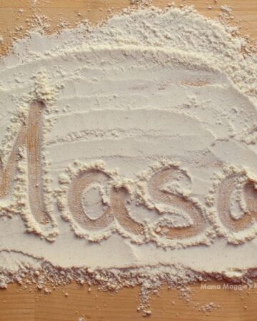 Masa harina spread out on a wooden surface with the word "Masa" written out.
