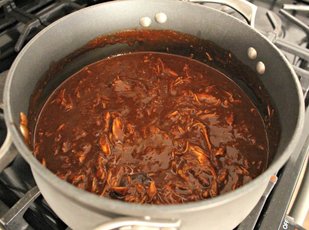 A pot of chicken mole on the stove.