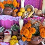 Offerings of bread, flowers, and fruits on a Dia de los Muertos altar.