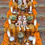 Stairs decorated with skeletons, marigolds, skulls, and candles.
