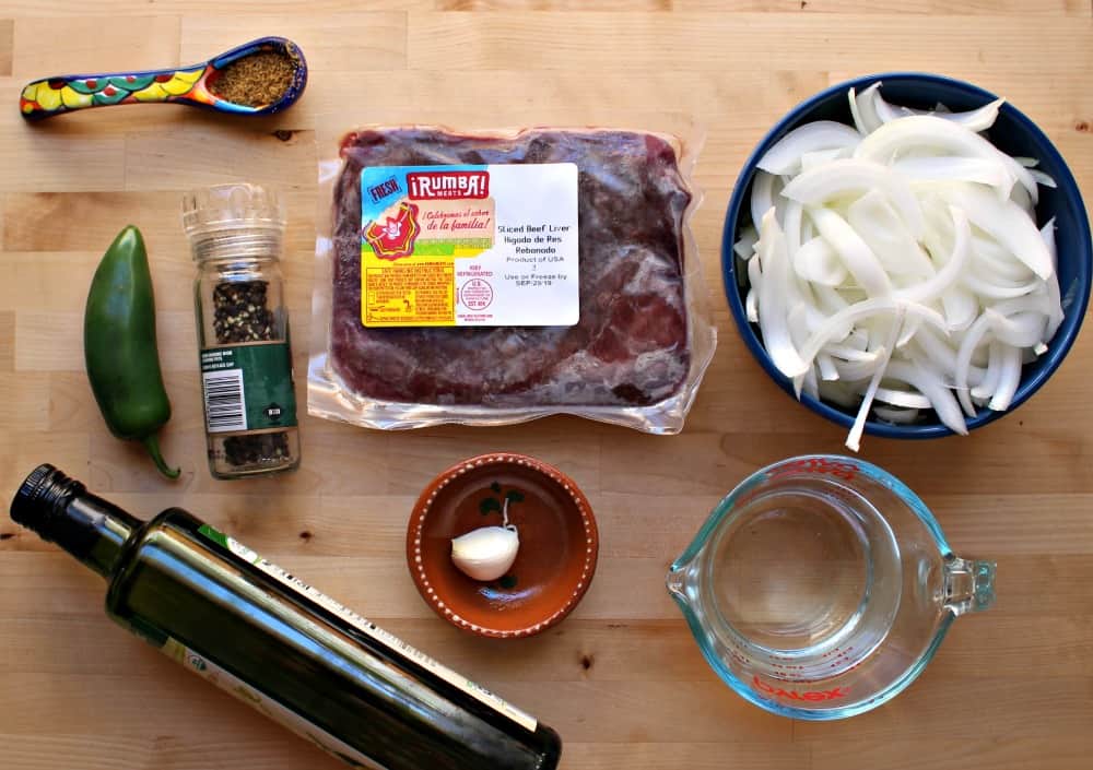 Ingredients for Mexican Beef Liver and Onions on a wooden surface.