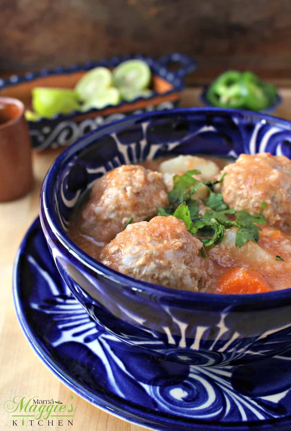 Mexican Albondigas Soup in a decorative blue bowl topped with cilantro.