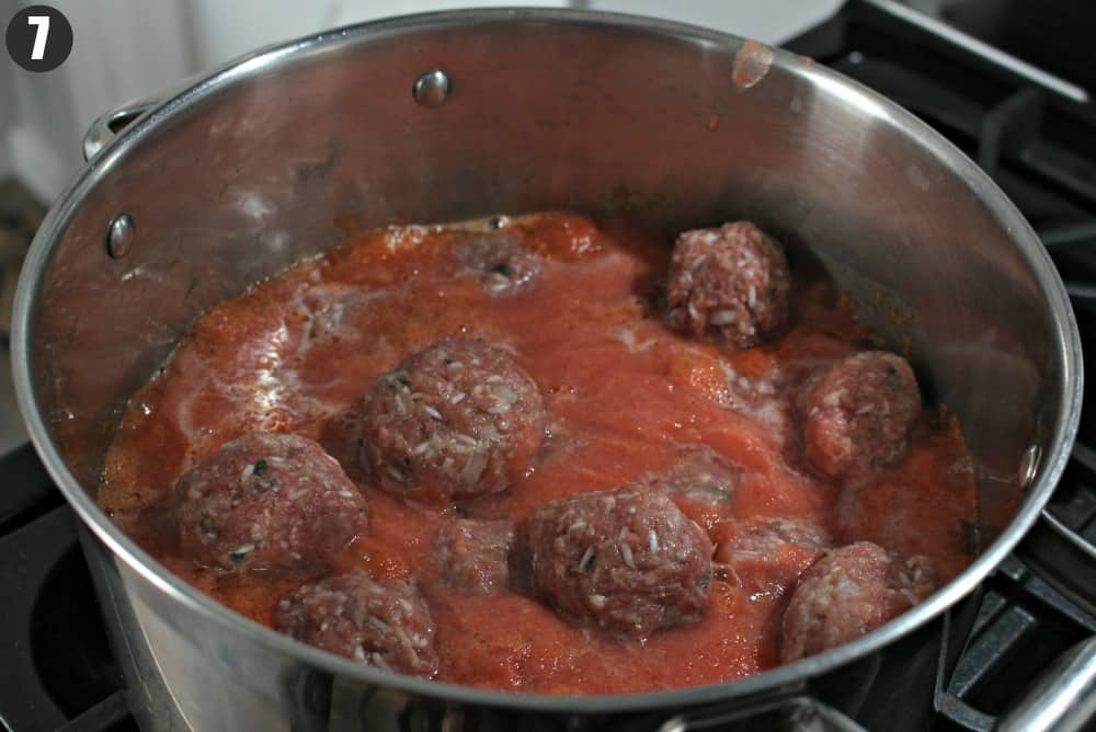 A stock pot with meatballs and tomato sauce.