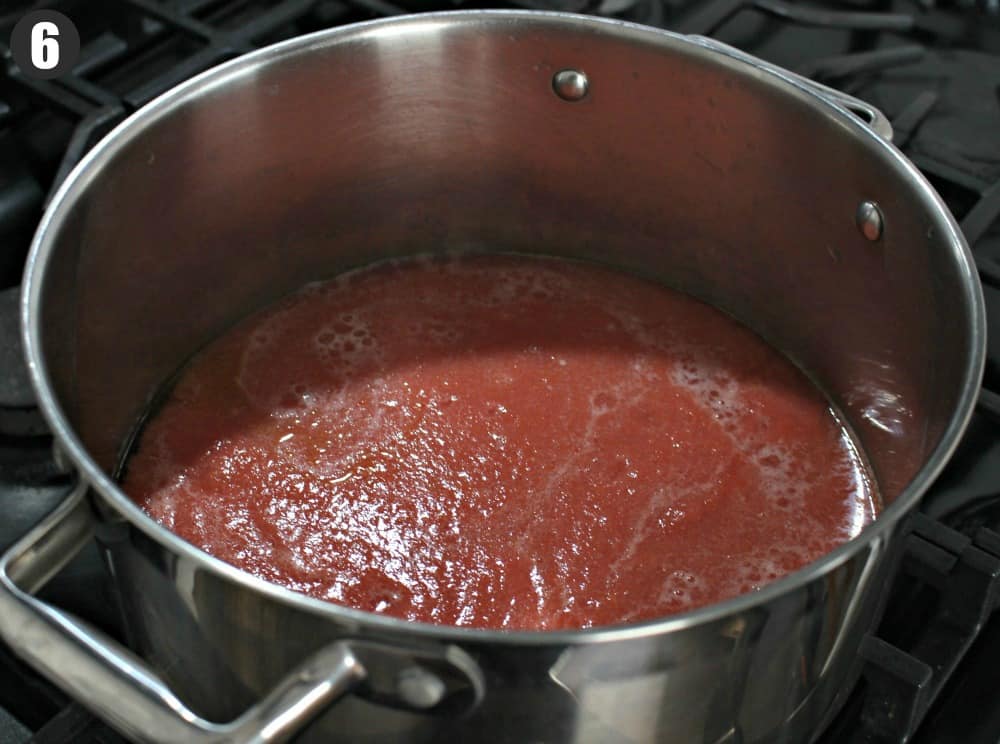 Tomato sauce simmering a large stock pot.