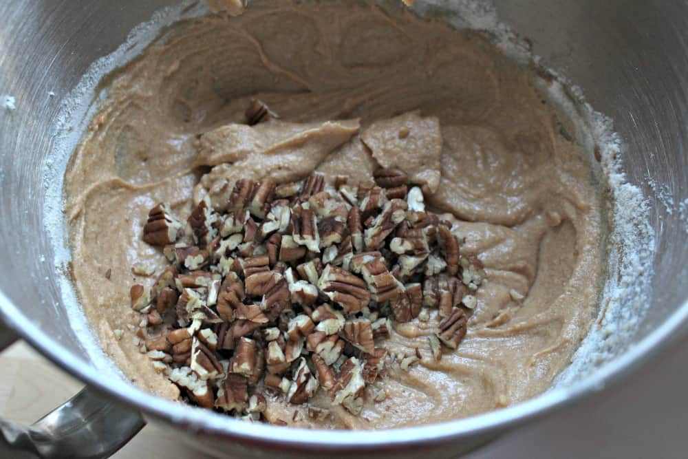 Chopped pecans on top of the mixed ingredients in a bowl.