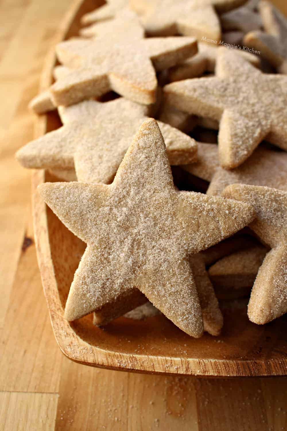 Star-shaped hojarascas cookies on a wooden platter.