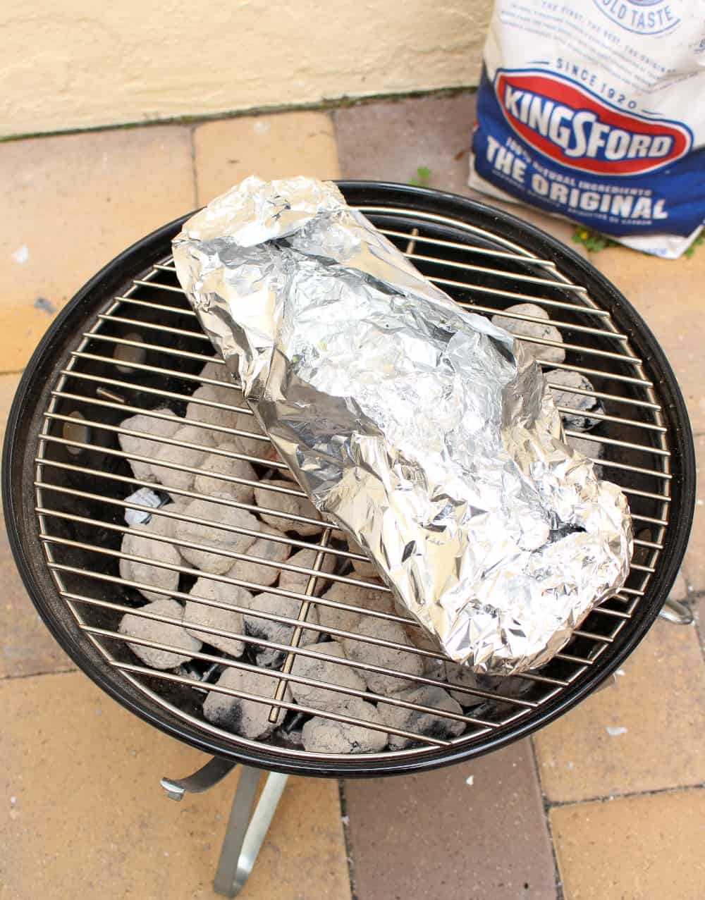 A foil packet of potatoes on a hot grill. 