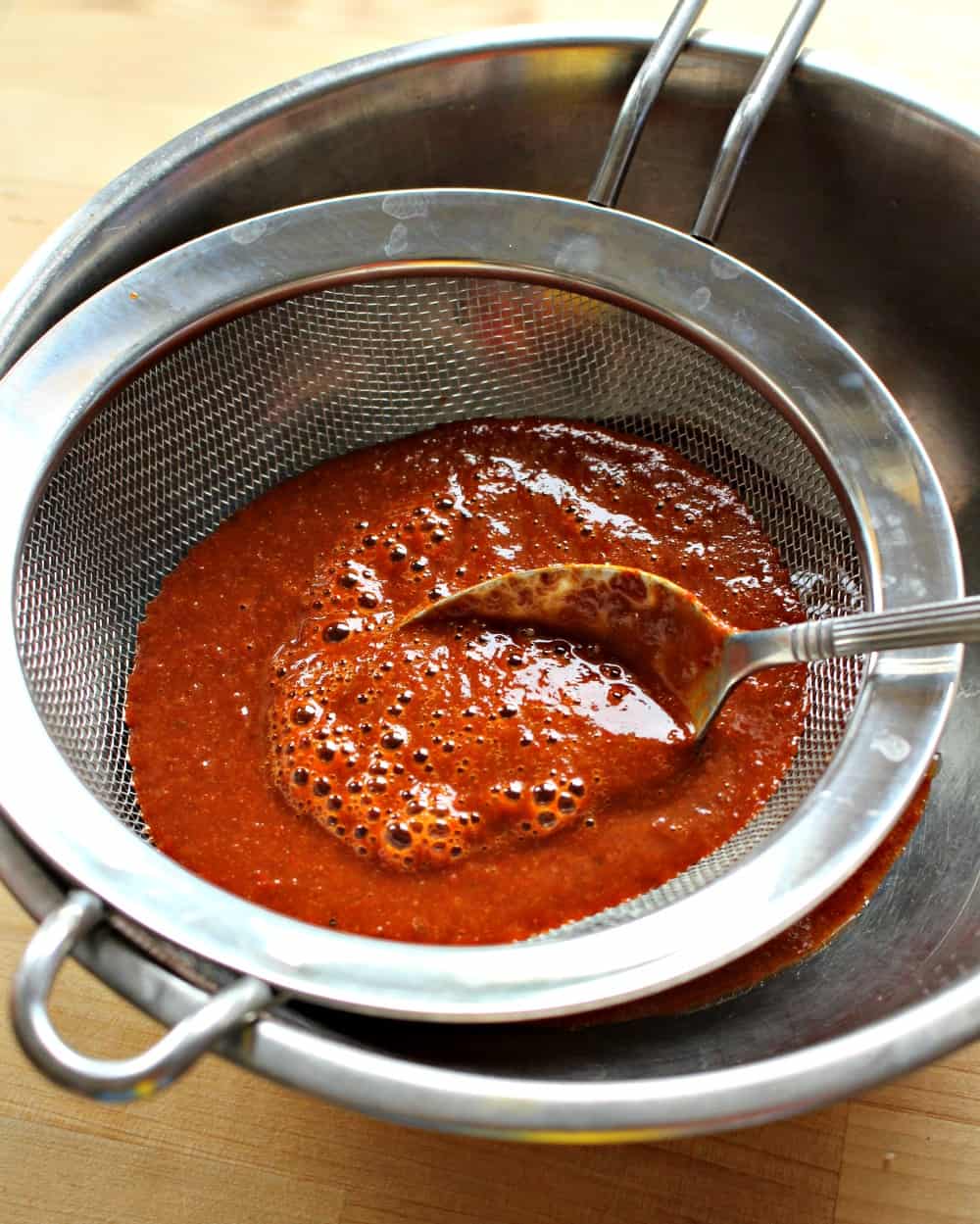 An image showing how to strain the diabla sauce.