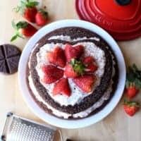 Mexican Chocolate Cake decorated with red heart-shaped strawberries.