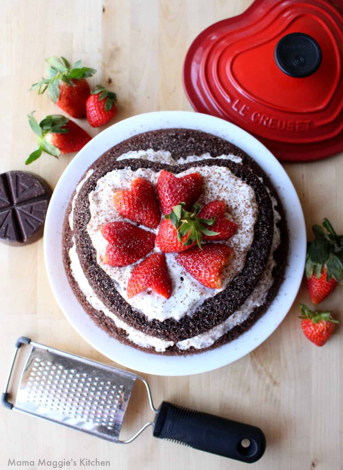 Mexican Chocolate Cake decorated with red heart-shaped strawberries.