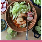 Shrimp Pozole in a clay bowl surrounded by the toppings.