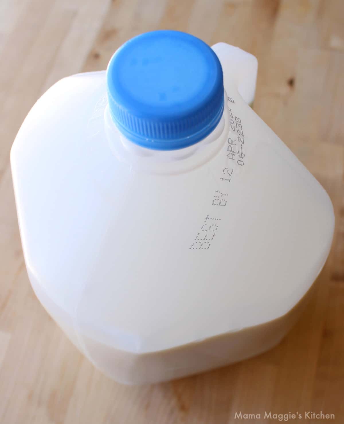 A gallon of milk with some of the liquid removed.