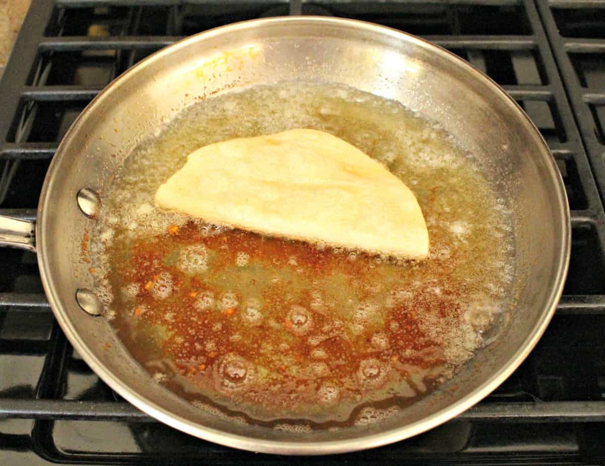 A taco dorado frying a skillet on a stove.