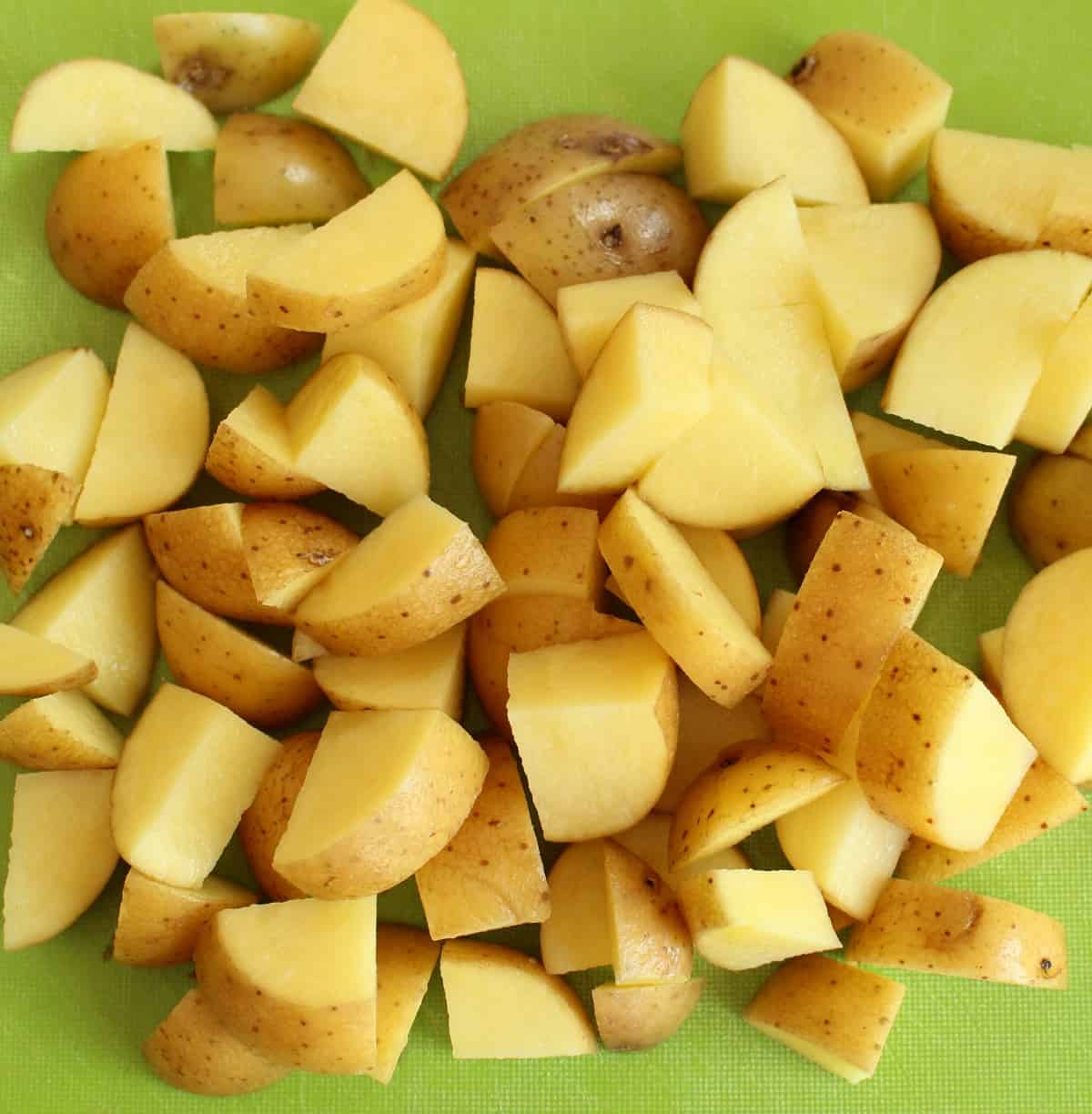 Diced potatoes on a green cutting board.