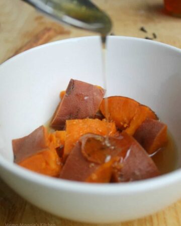 The candied syrup drizzling over the sweet potatoes in a white bowl.
