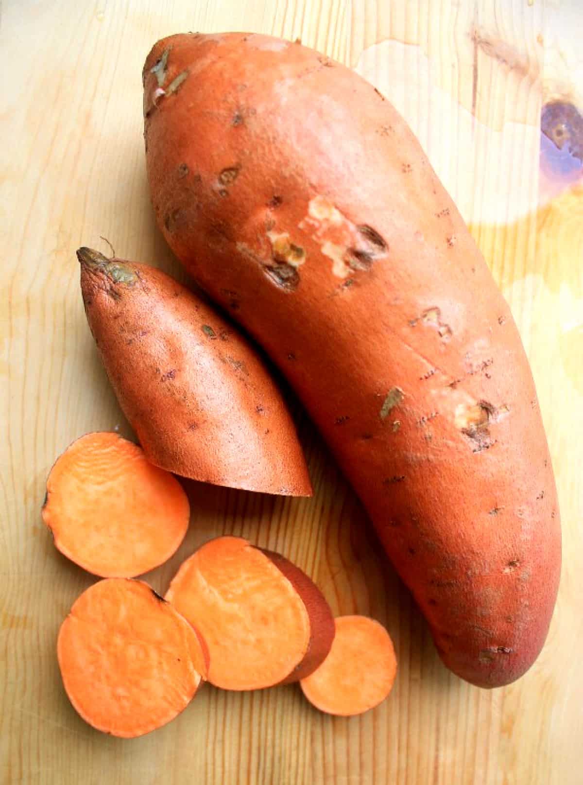 A large sweet potatoes next to sliced sweet potatoes.