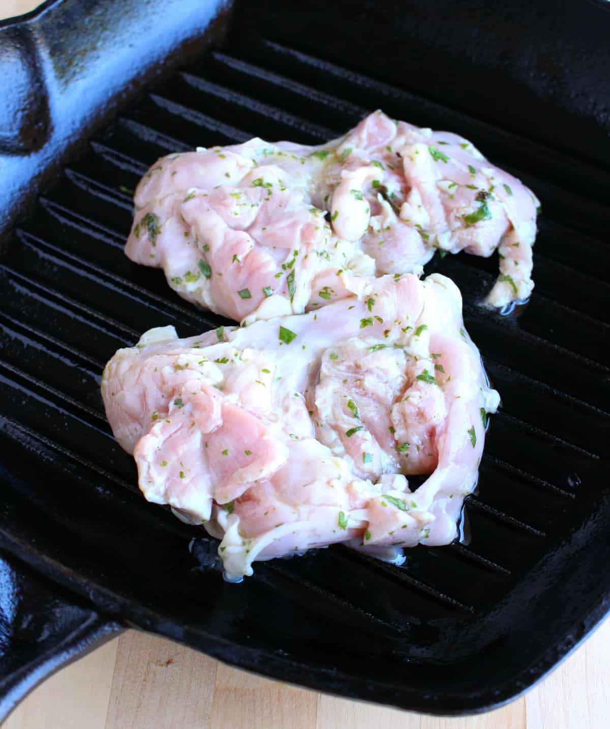 Chicken thighs grilling on a grill pan.