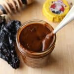 Mole sauce in a jar with a spoon inside.