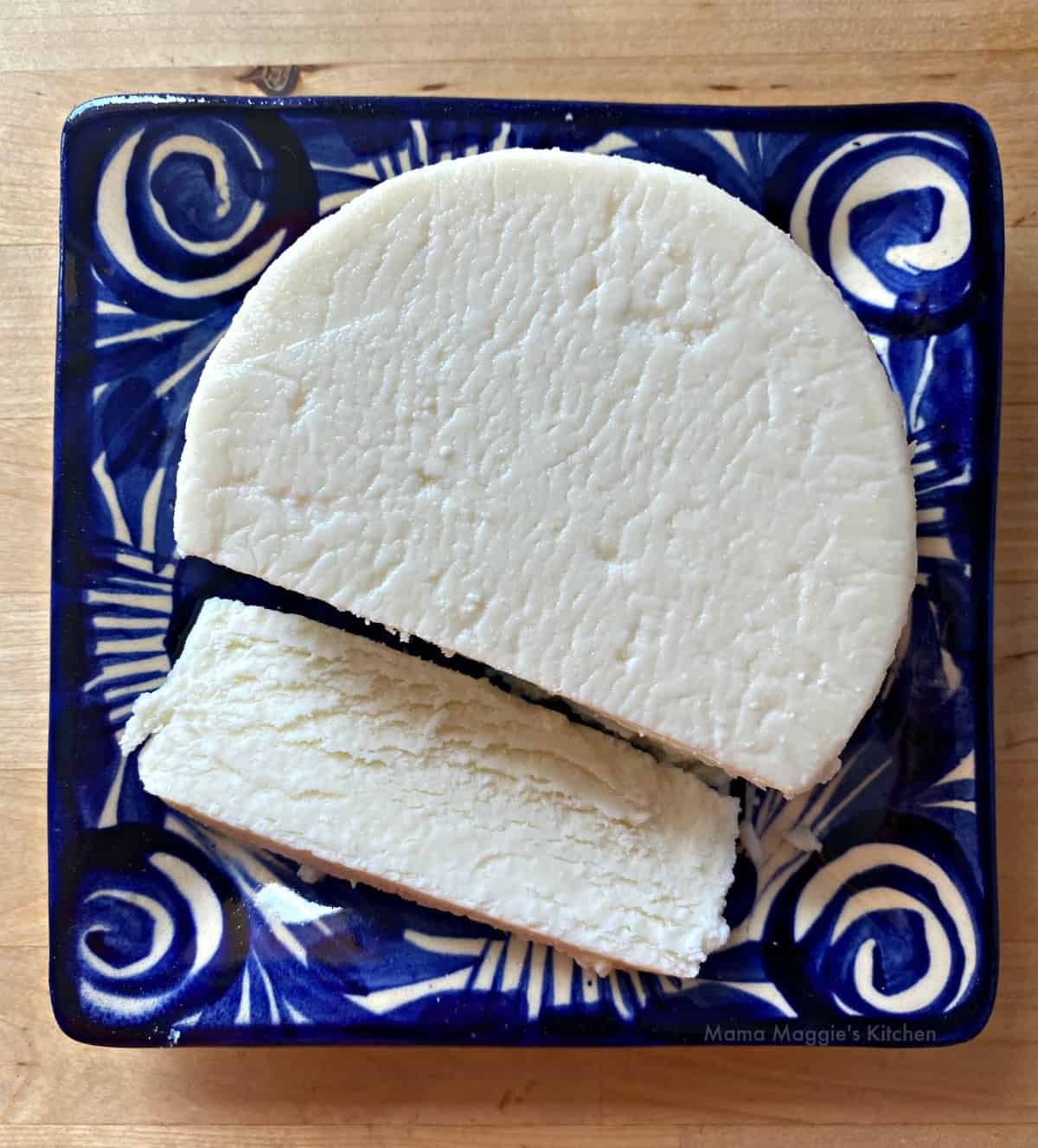 A blue and white plate with queso fresco sliced.