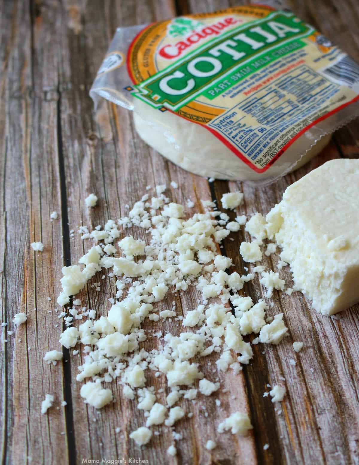 Crumbled cotija cheese next to a package of cheese.