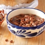 A bowl of pinto beans next to dried beans.