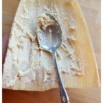 A spoon spreading masa for tamales on a corn husk.
