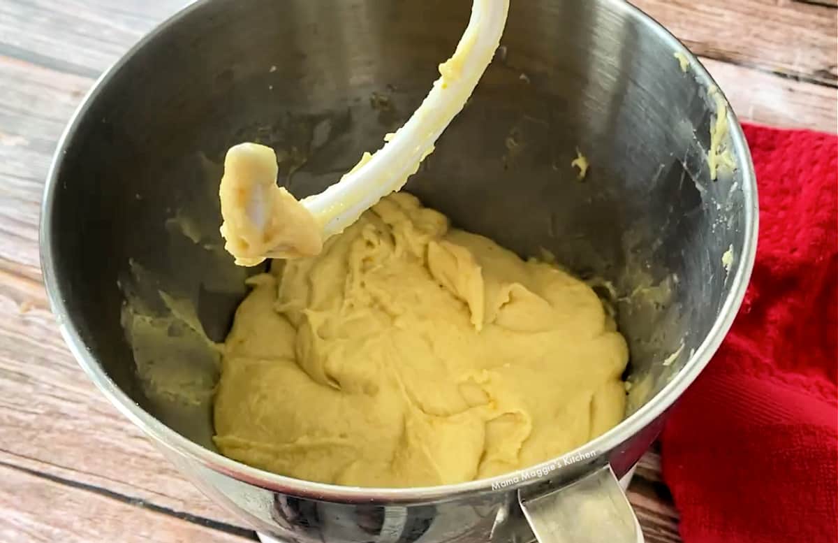 The dough inside a mixing bowl with the hook attachment.