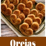 A stack of orejas (Mexican pan dulce) on a golden serving platter.
