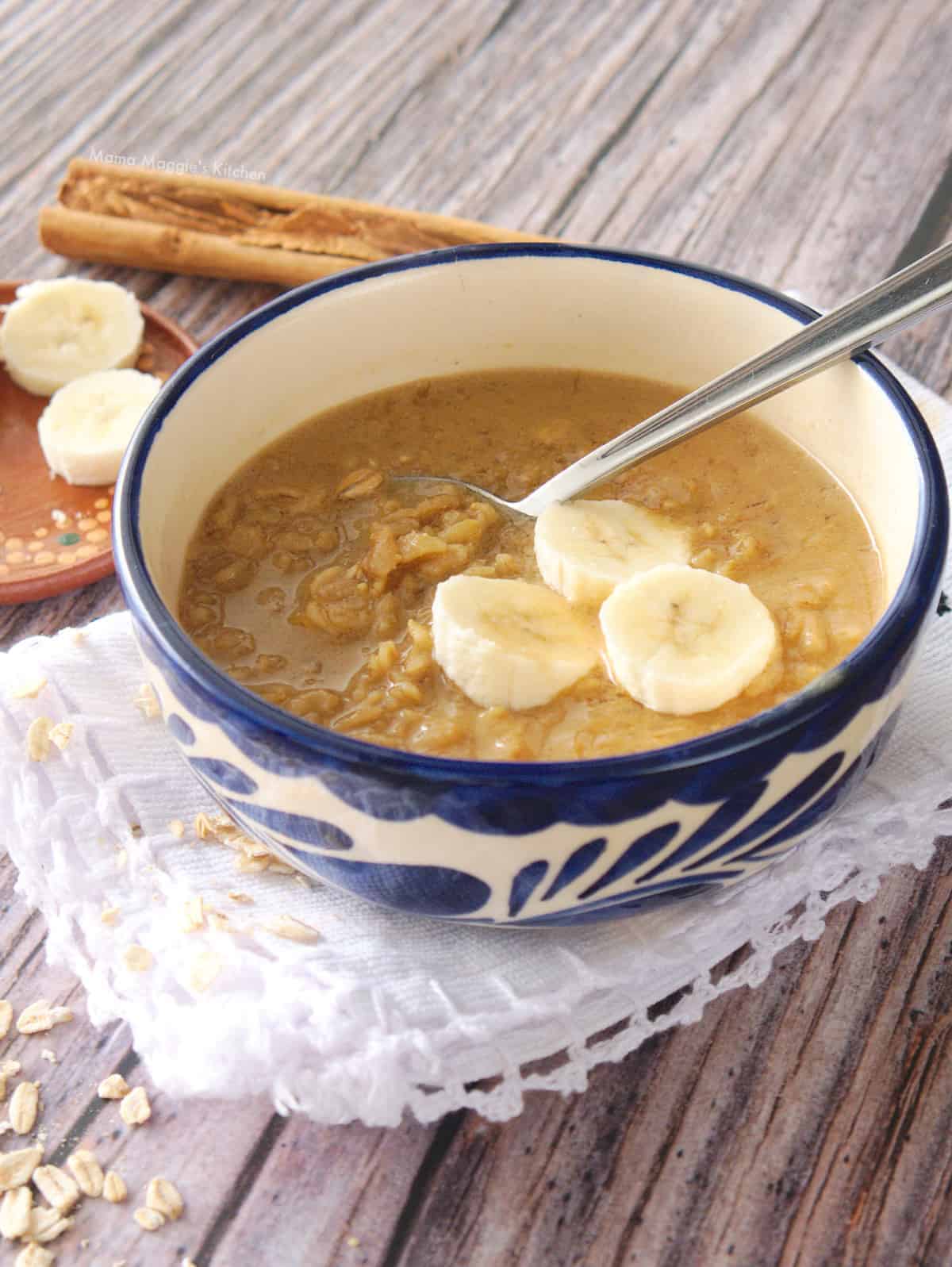 Mexican avena served in a blue bowl and topped with banana slices.