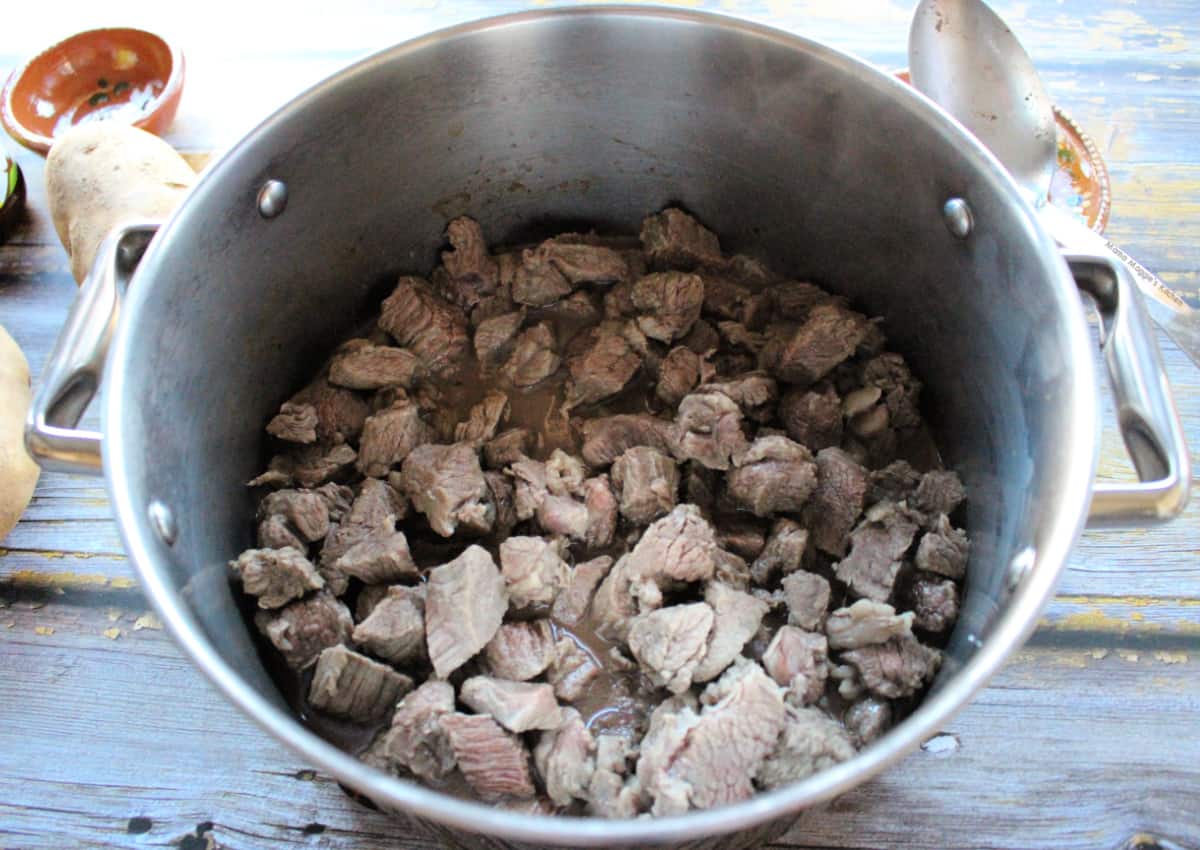 Beef cooking in a stock pot.