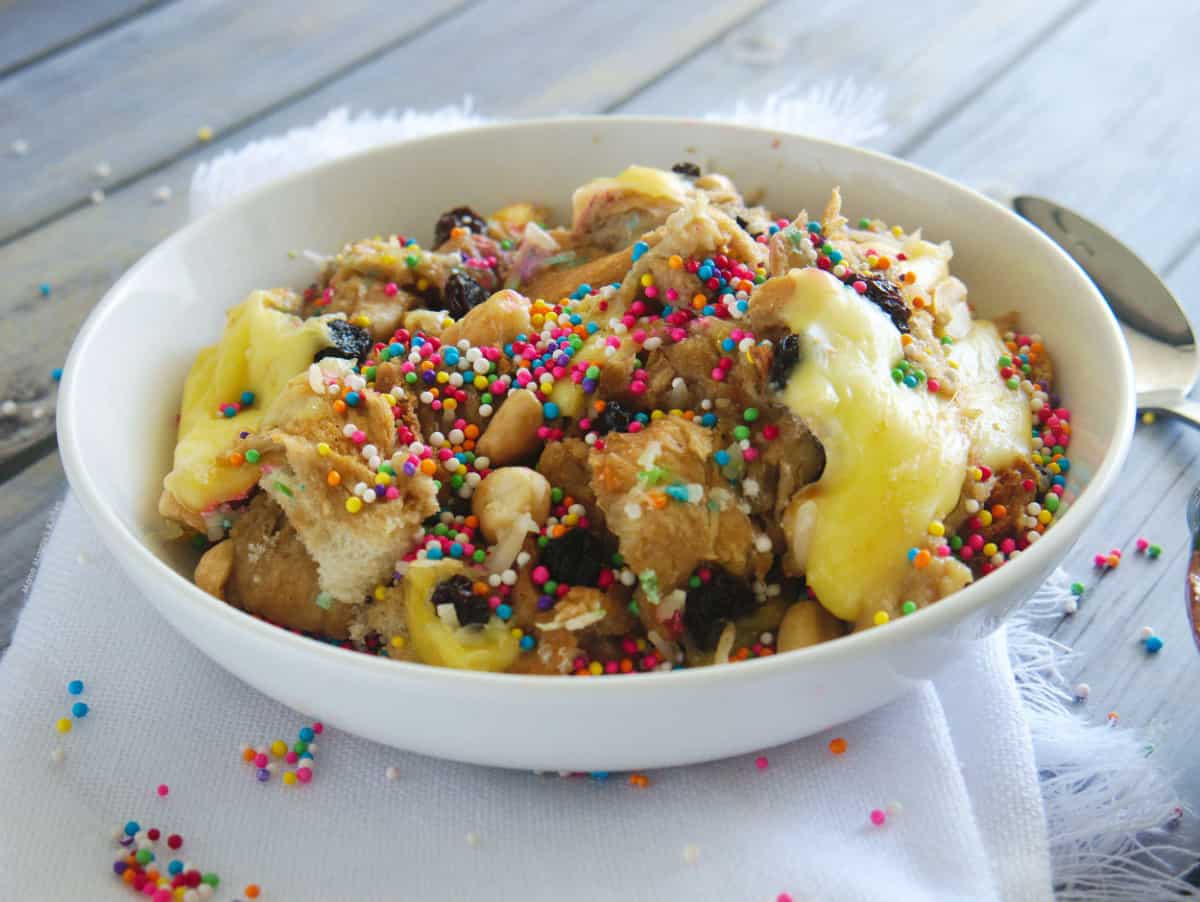Capirotada (or Mexican Bread Pudding) served in a white bowl and topped with sprinkles.