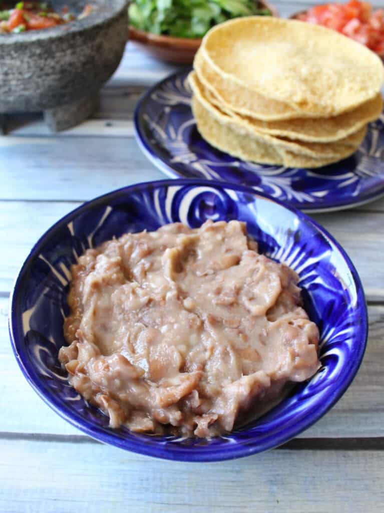 Refried beans in a decorative blue plate.
