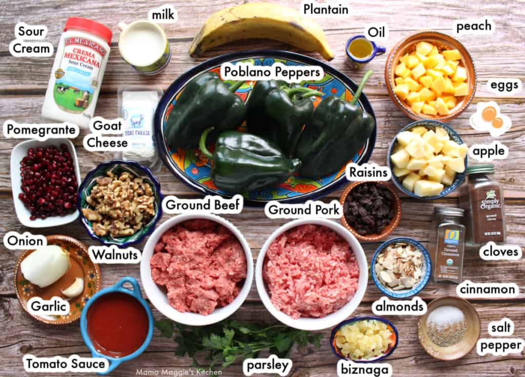 A picture with the ingredients needed for chiles en nogada laid out and labeled on a wooden surface.