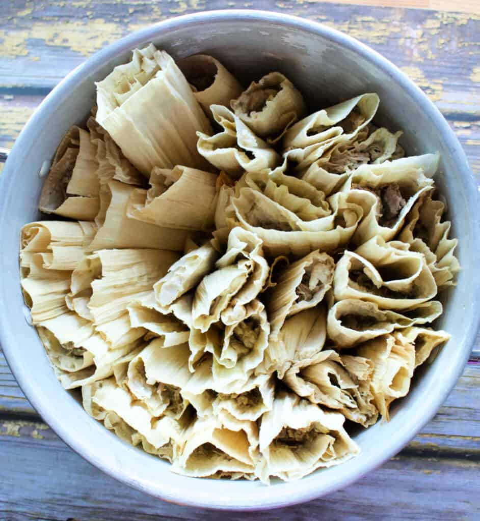 A steamer pot filled with uncooked tamales.
