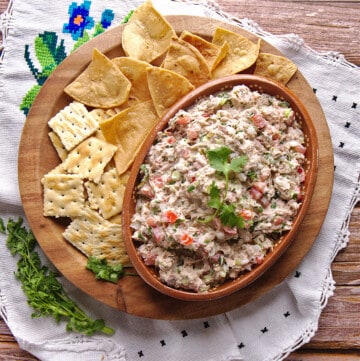 Ensalada de Atún served in a clay bowl and surrounded by chips and saltine crackers.